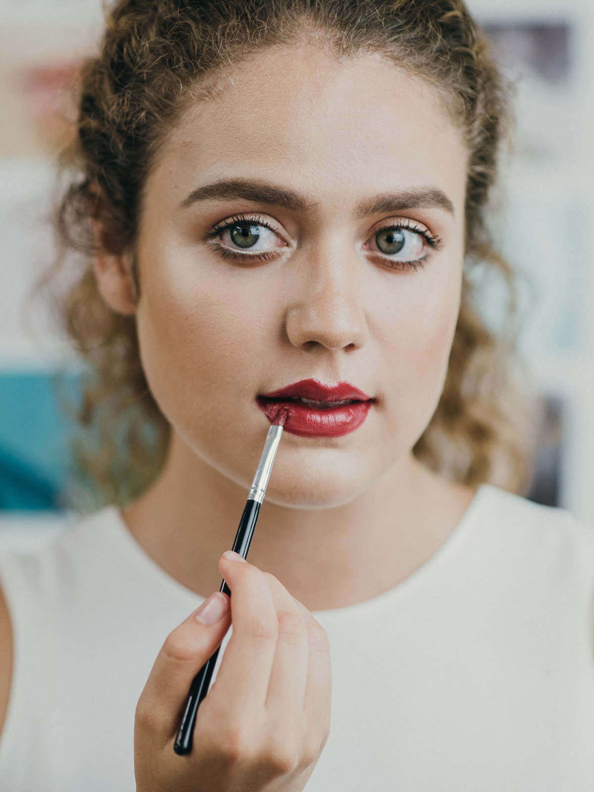 Mädchen malt sich rote Lippen