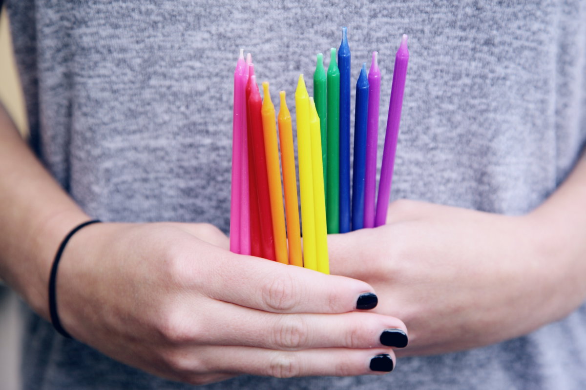 Hände, die bunte Kerzen halten