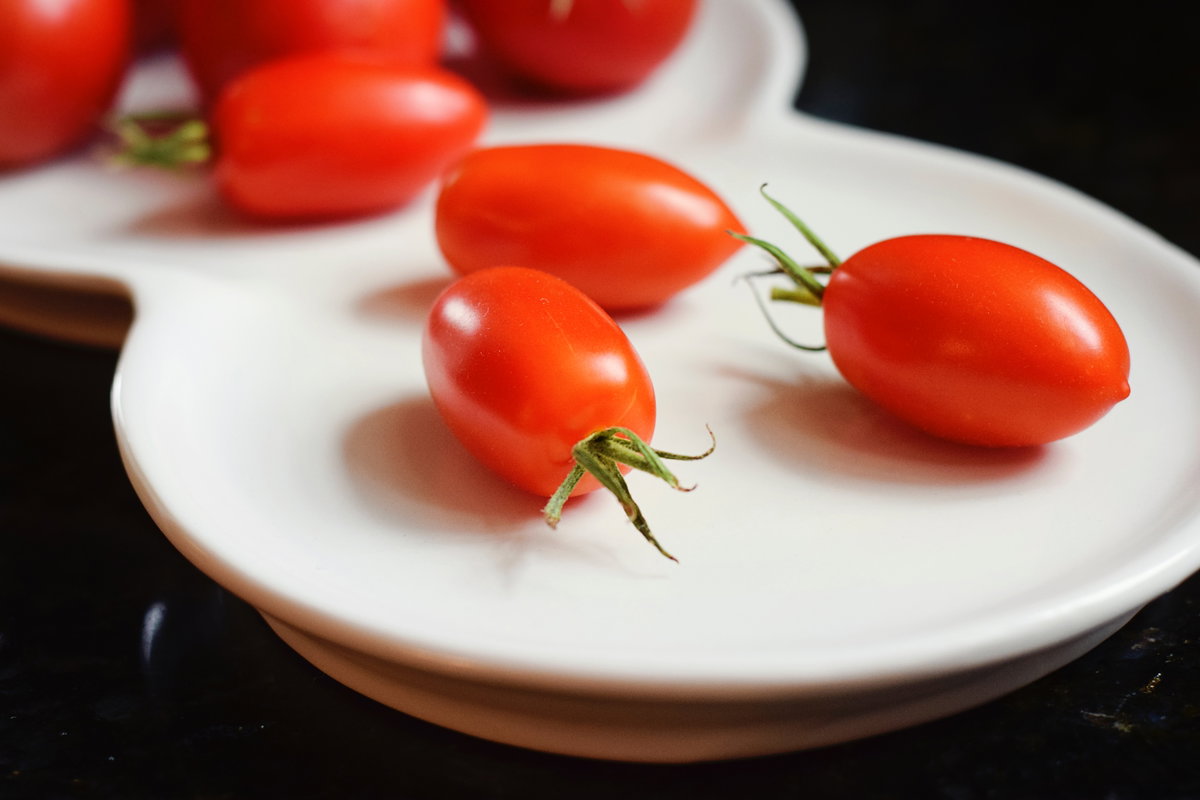 Kleine Tomaten auf Porzellanteller
