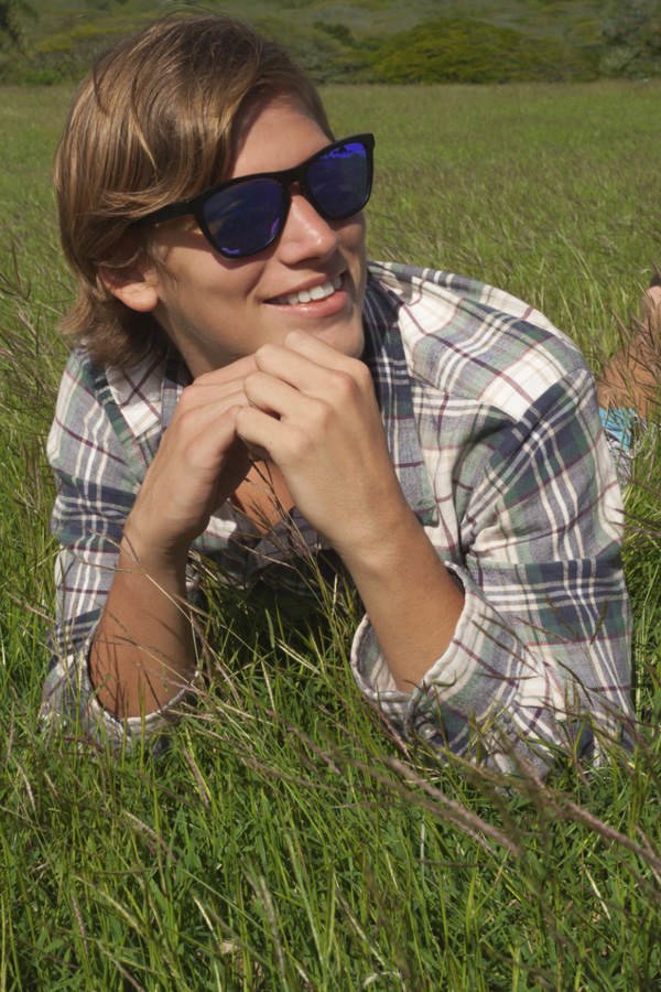 Junge auf einer Wiese mit Sonnenbrille