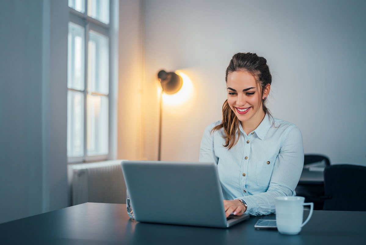 Junge Frau sitzt am Laptop