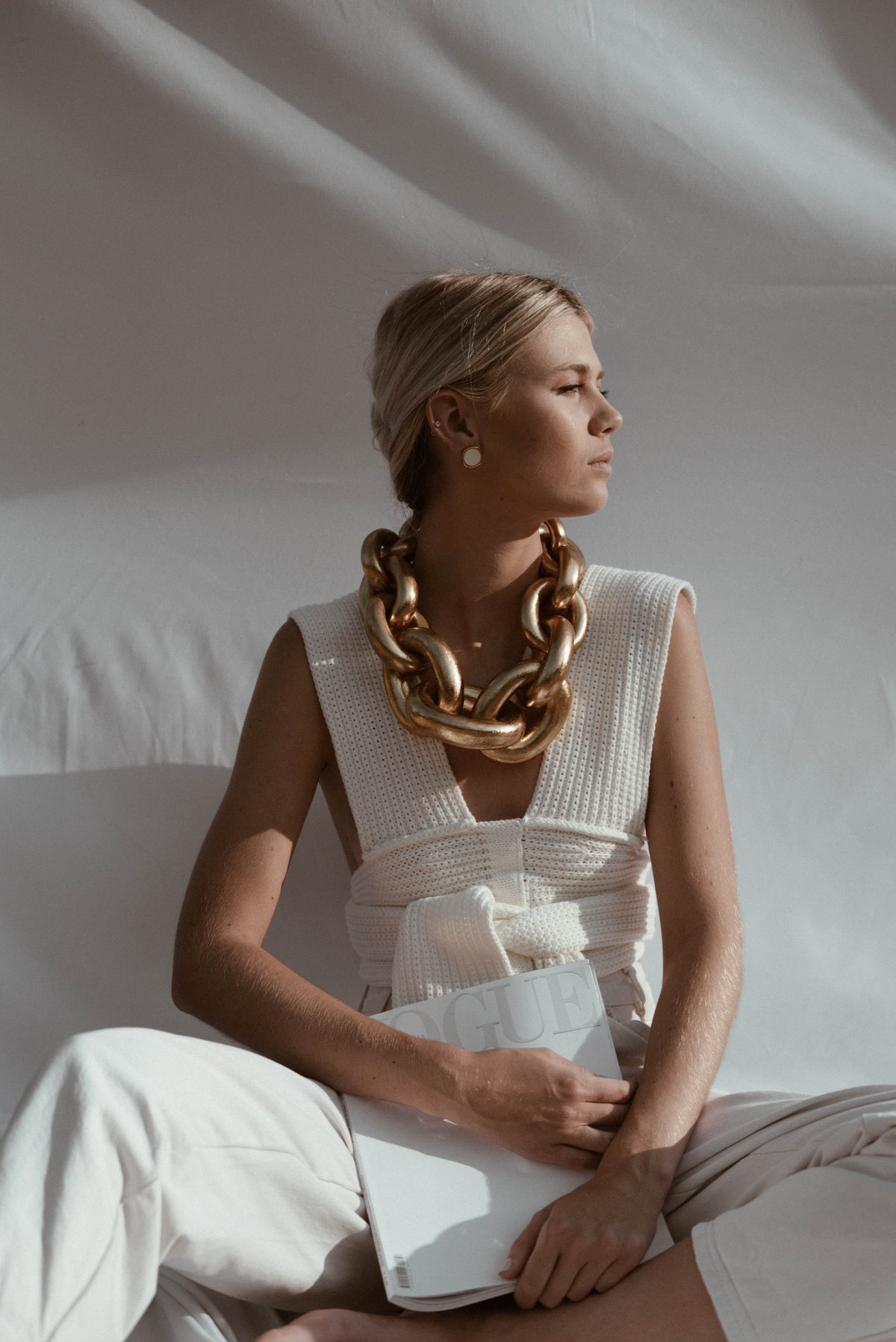 Horoskop: Frau mit weißem Outfit und Goldkette