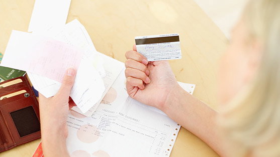 maedchen-mit-kassenzettel-ec-karte-und-rechnungen-in-der-hand-557x313-314437-314373.jpg