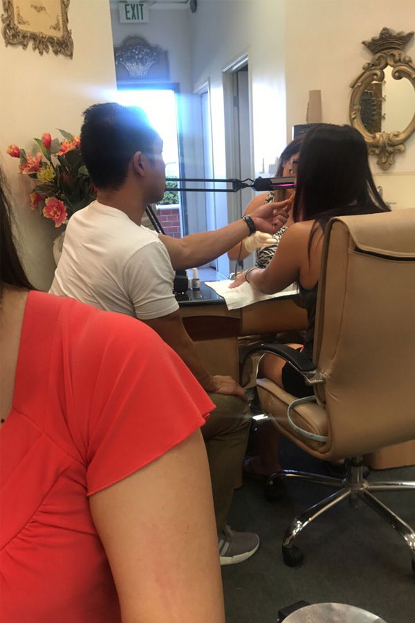 Typ füttert seine Freundin im Nagelstudio mit Chicken Nuggets